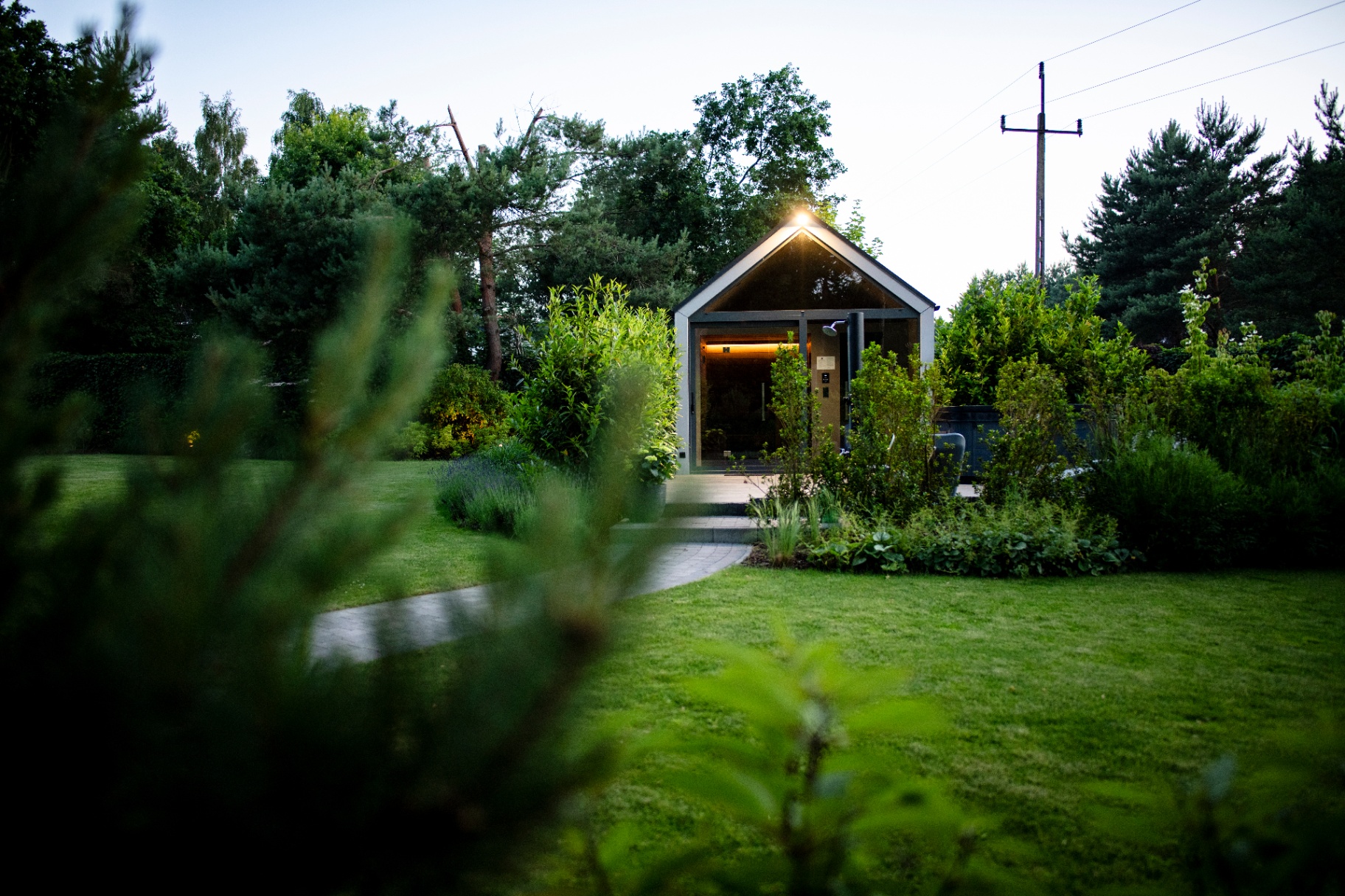 Domek AQUA Your Stay o zmierzchu, otoczony ogrodem